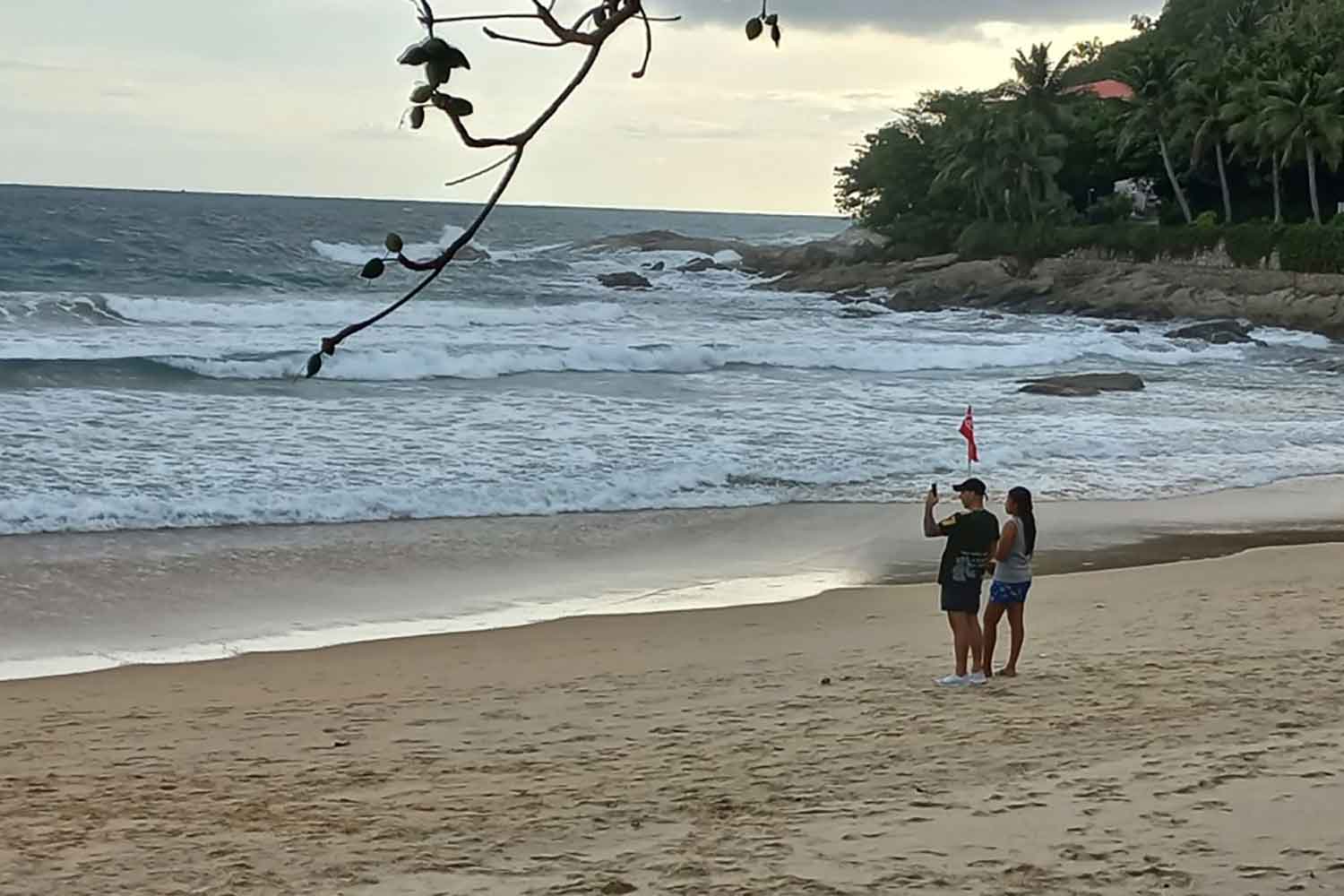 Tourists relax on a Phuket beach on Tuesday. (Photo: Achadthaya Chuenniran)