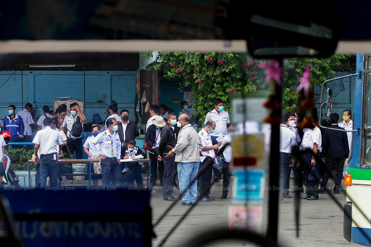 Bus drivers, fare collectors and staff from the Bangkok Mass Transit Authority turn up at a bus depot in Klong Toey for Covid-19 testing under supervision of a team of medical personnel from the Rural Doctor Society on Thursday. Bus drivers and fare collectors are an at-risk group and the number of infections among them has exceeded 300 during the lockdown. (Photo: Apichit Jinakul)