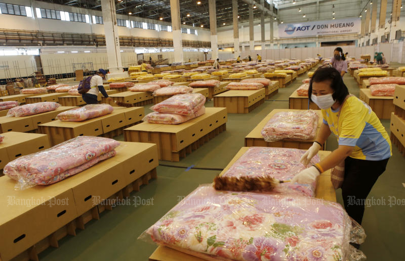 Volunteers prepare mattresses and blankets as an air cargo warehouse at Don Mueang airport is converted into a new field hospital before it opens on Thursday. (Photo: Apichit Jinakul)