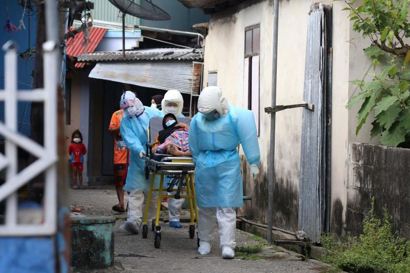 FILE PHOTO: Workers clad in PPE gear wheel a patient with Covid-19 symptoms to be brought to hospital from a village in Pattani on July 19, 2021, as Thailand seeks to contain a surge in coronavirus cases. (AFP)