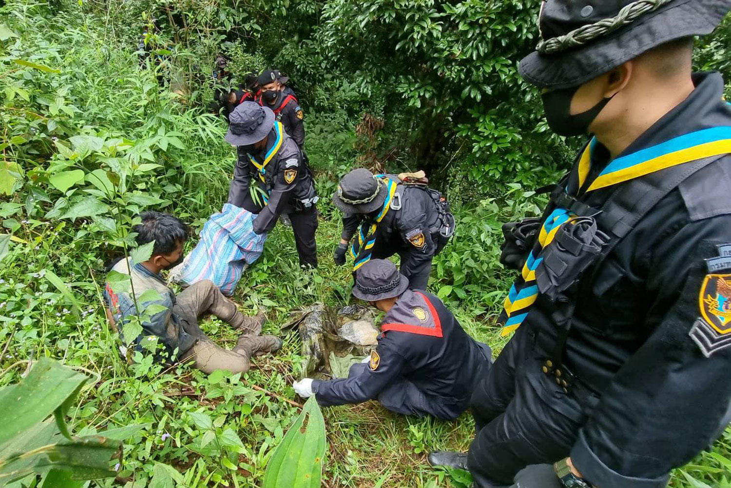 Officers guard one of the two drug couriers caught following a brief clash with troops from the Pha Muang task force in Mae Ai district of Chiang Mai on Saturday afternoon. (Photo: Pha Muang task force Facebook page) Officers guard one of the two drug couriers caught following a brief clash with troops from the Pha Muang task force in Mae Ai district of Chiang Mai on Saturday afternoon. (Photo: Pha Muang task force Facebook page)