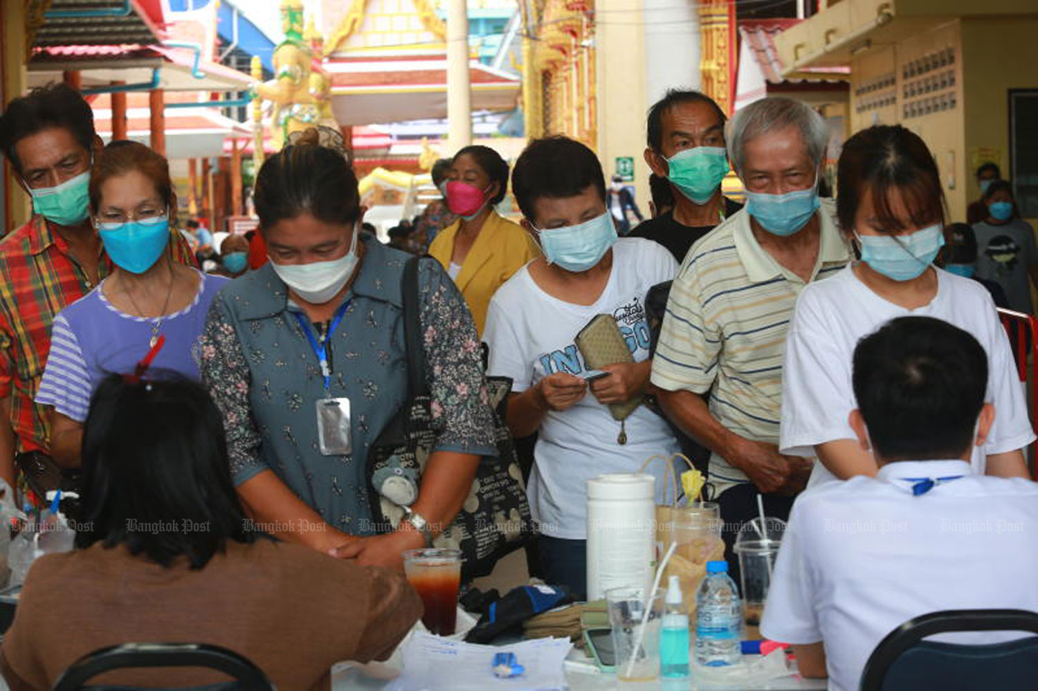 People in vulnerable groups queue to receive a Pfizer vaccine shot at Wat Bang Phli Yai Klang in Bang Phli district, Samut Prakan on Saturday. (Photo by Somchai Poomlard)