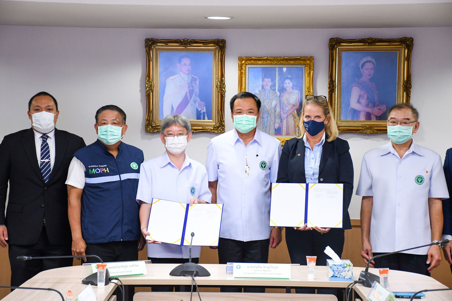 The signed purchase contract, held by Dr Opas Karnkawinpong, director-general of the Department of Disease Control, and Deborah Seifert, executive of Pfizer Thailand and Indochina. Public Health Minister Anutin Charnvirakul (centre) and senior officials witnessed the signing at the Public Health Ministry on Friday. (Photo supplied)