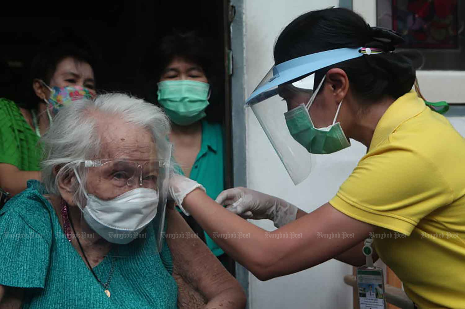 A health worker gives the AstraZeneca vaccine to a bedridden patient, Malai Phensut, 96, at her home in Sathon district, Bangkok, on Thursday. (Photo: Apichart Jinakul)