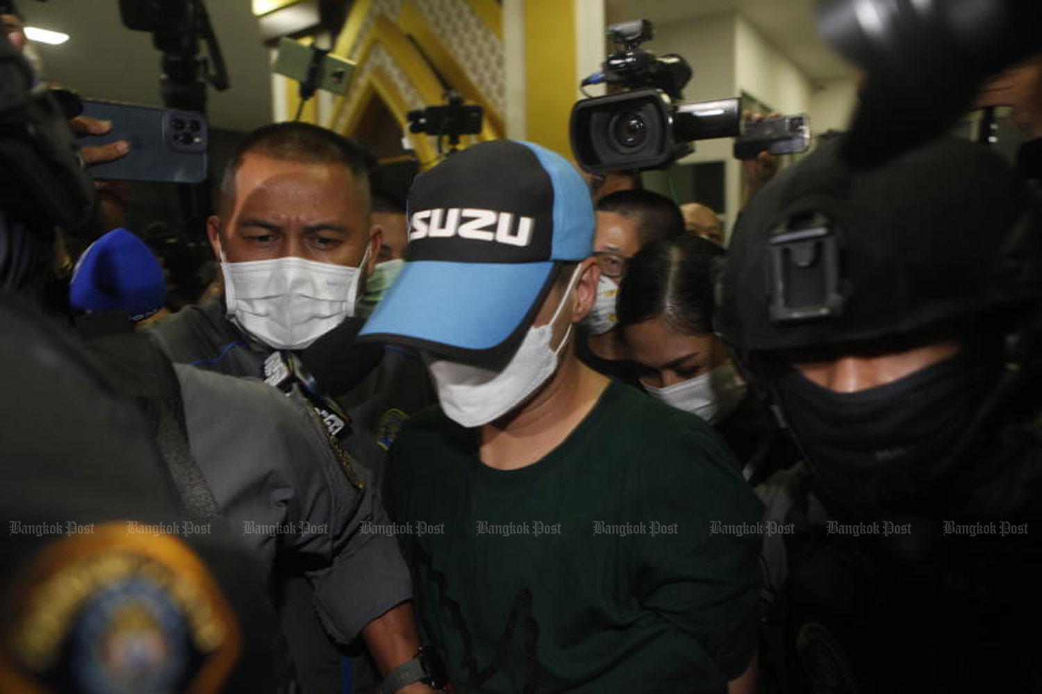 Pol Col Thitisan Utthanaphon is taken from the Crime Suppression Division to return to Muang police station in Nakhon Sawan on Thursday night. (Photo: Nutthawat Wicheanbut)