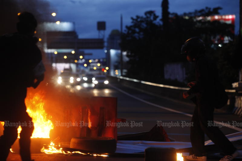 Members of the Thalugaz movement burn tyres during an anti-government rally in Din Daeng area on Wednesday. (Photo: Nutthawat Wicheanbut)