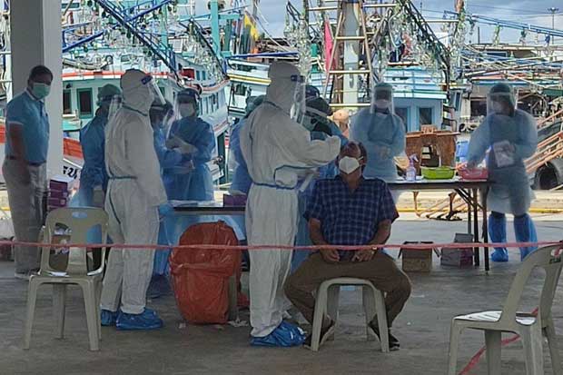 Healthcare workers give Covid-19 tests at a trawler pier in Phuket. (Photo: Achadtaya Chuenniran)