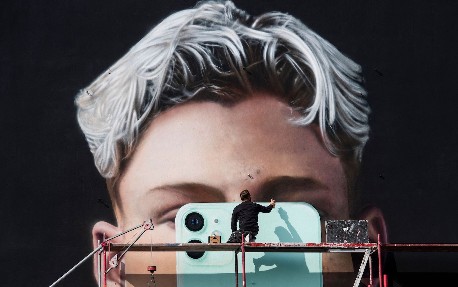 A graphic artist paints a billboard for the smartphone manufacturer Apple, in Berlin. (AFP File Photo) A graphic artist paints a billboard for the smartphone manufacturer Apple, in Berlin. (AFP File Photo)