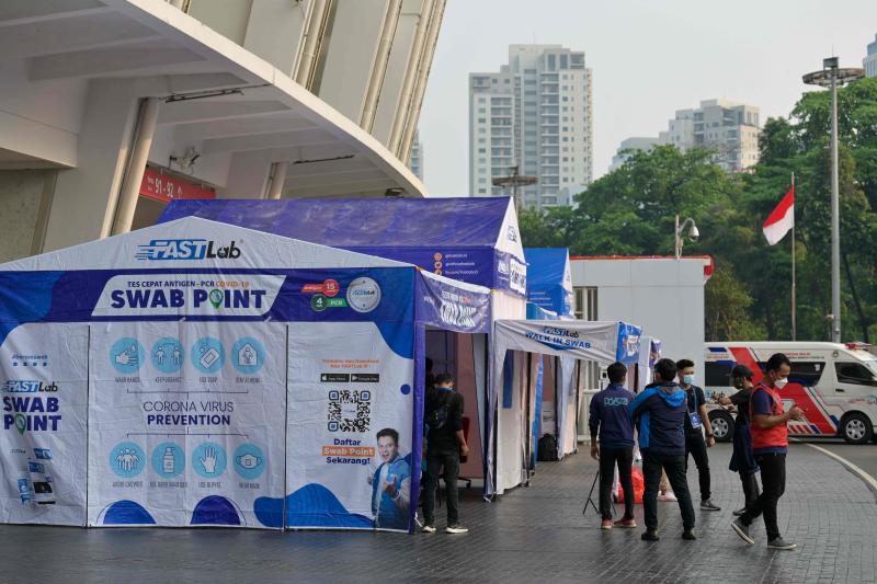 FILE PHOTO: Officials gather outside a booth conducting Covid-19 antigen tests ahead of an Indonesian National League 1 football match, the first after a one and a half year hiatus due to the pandemic, outside the Bung Karno stadium in Jakarta on Aug 27, 2021. (AFP)