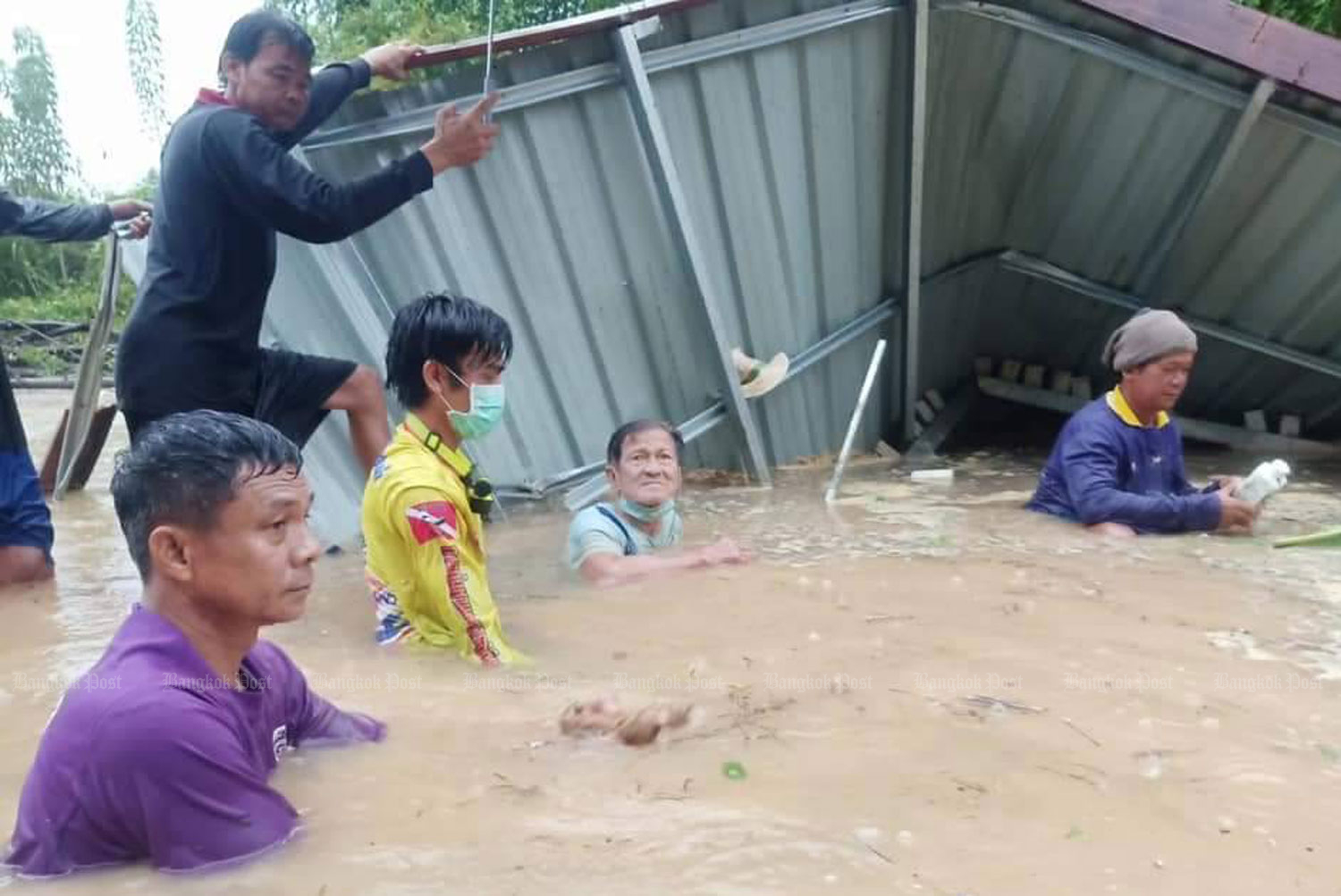 Rescuers work to free the man from wreckage of his collapsed kitchen in the Yom River on Thursday morning. (Photo: Chinnawat Singha)