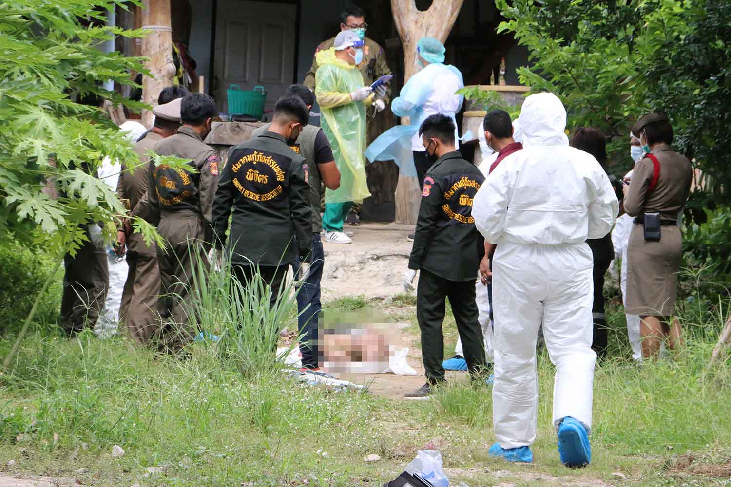 Police inspect the shooting scene at a house in Phichit as rescue workers prepare to take the bodies of people shot dead by a prison official on Wednesday. (Photo: Sitthipoj Kebui)