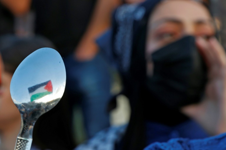 Arab-Israeli protesters lift spoons, reportedly the digging tool used by six Palestinians who escaped from Israel's Gilboa prison, as they demonstrate in the city of Umm al-Fahm in northern Israel on September 10, 2021 Arab-Israeli protesters lift spoons, reportedly the digging tool used by six Palestinians who escaped from Israel's Gilboa prison, as they demonstrate in the city of Umm al-Fahm in northern Israel on September 10, 2021