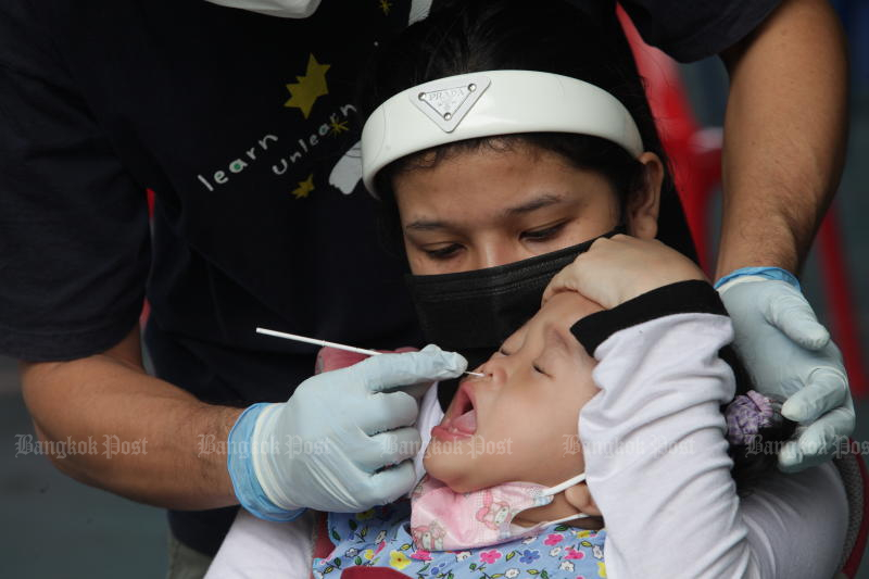 A health worker takes a swab for Covid-19 testing from a baby at Sammakeesongkroh School in Klong Toey district, Bangkok, on Sunday. (Photo: Apichart Jinakul)