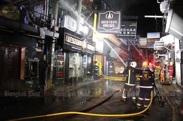 Firefighters continue to spray water on the burned out Club Nashaa building after bringing the blaze in Pattaya's Walking Street under control early on Monday morning. (Photo: Chaiyot Pupattanapong)