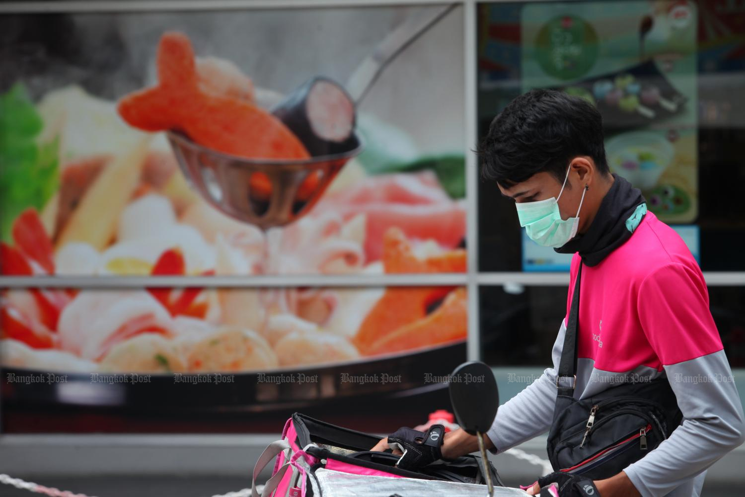 A food delivery rider sets off after receiving an order. Photo by Apichart Jinakul.