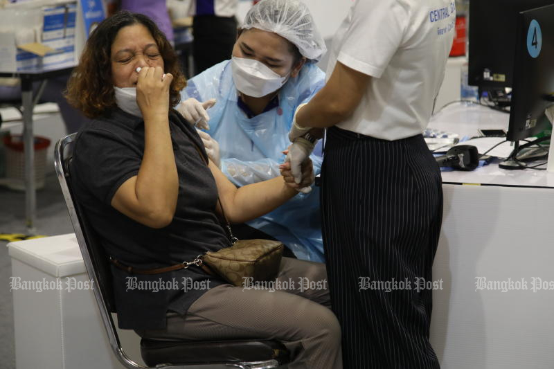 A woman reacts as a nurse administers a Covid-19 vaccine shot at Central Plaza in Lard Phrao on Sunday. (Photo: Arnun Chonmahatrakool)