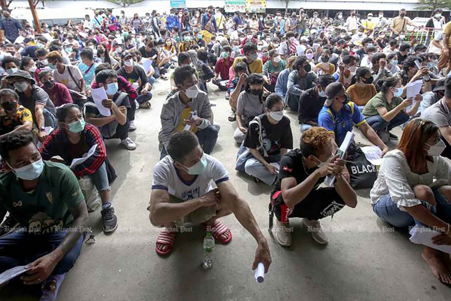 Migrant workers wait for their turn to be vaccinated at the Bang Yai City Central Market in Nonthaburi on Monday. (Photo: Pattarapong Chatpattarasill)