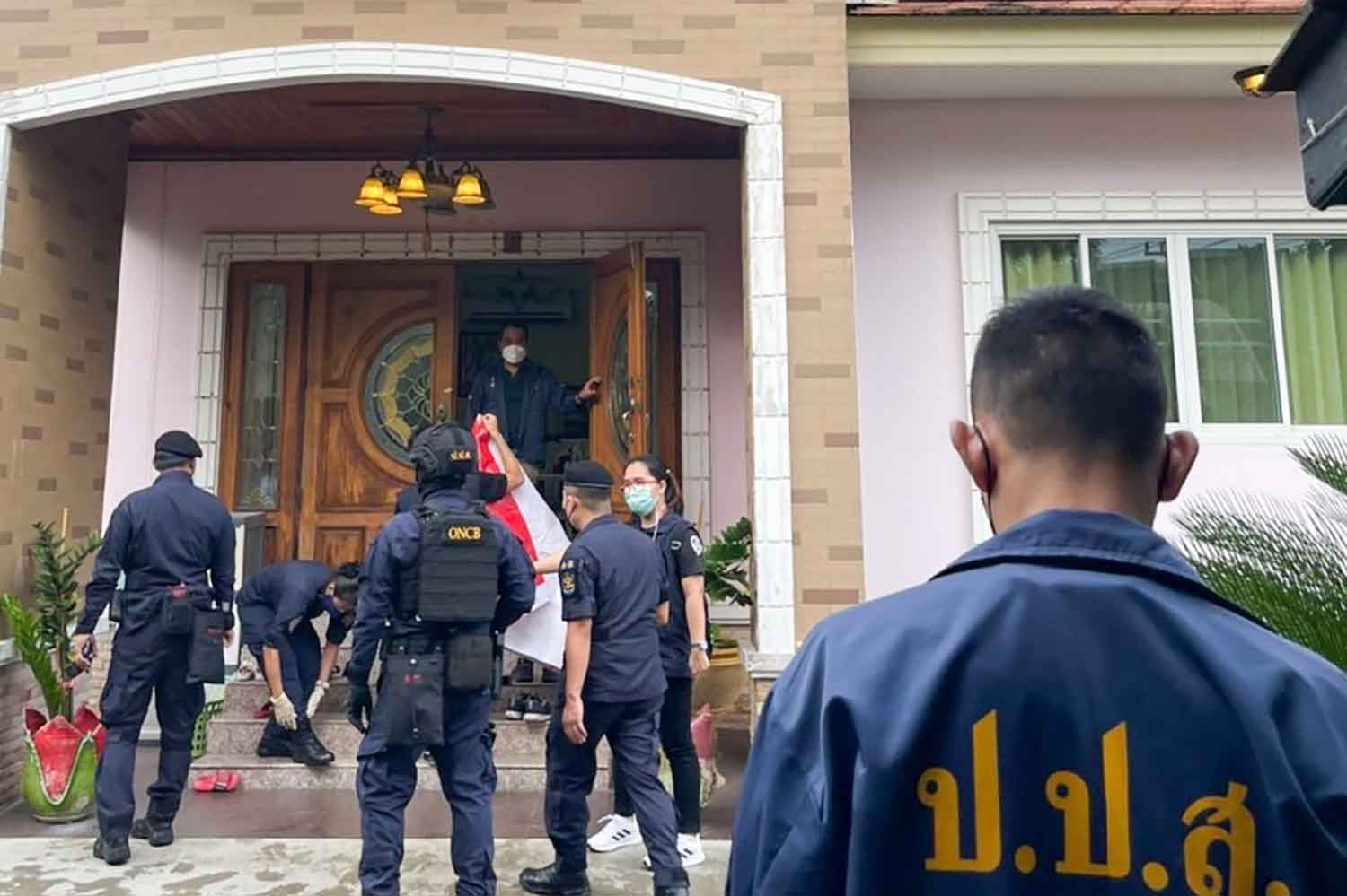 Officials from the Office of the Narcotics Control Board search a house in Samphran district, Nakhon Pathom, on Wednesday to impound assets suspected of being acquired through the illicit drug trade. (Photo supplied)