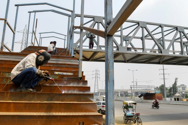 Workers build a bridge in Ghaziabad, India. The Asian Development Bank has cut its growth forecast for developing Asia. Workers build a bridge in Ghaziabad, India. The Asian Development Bank has cut its growth forecast for developing Asia.