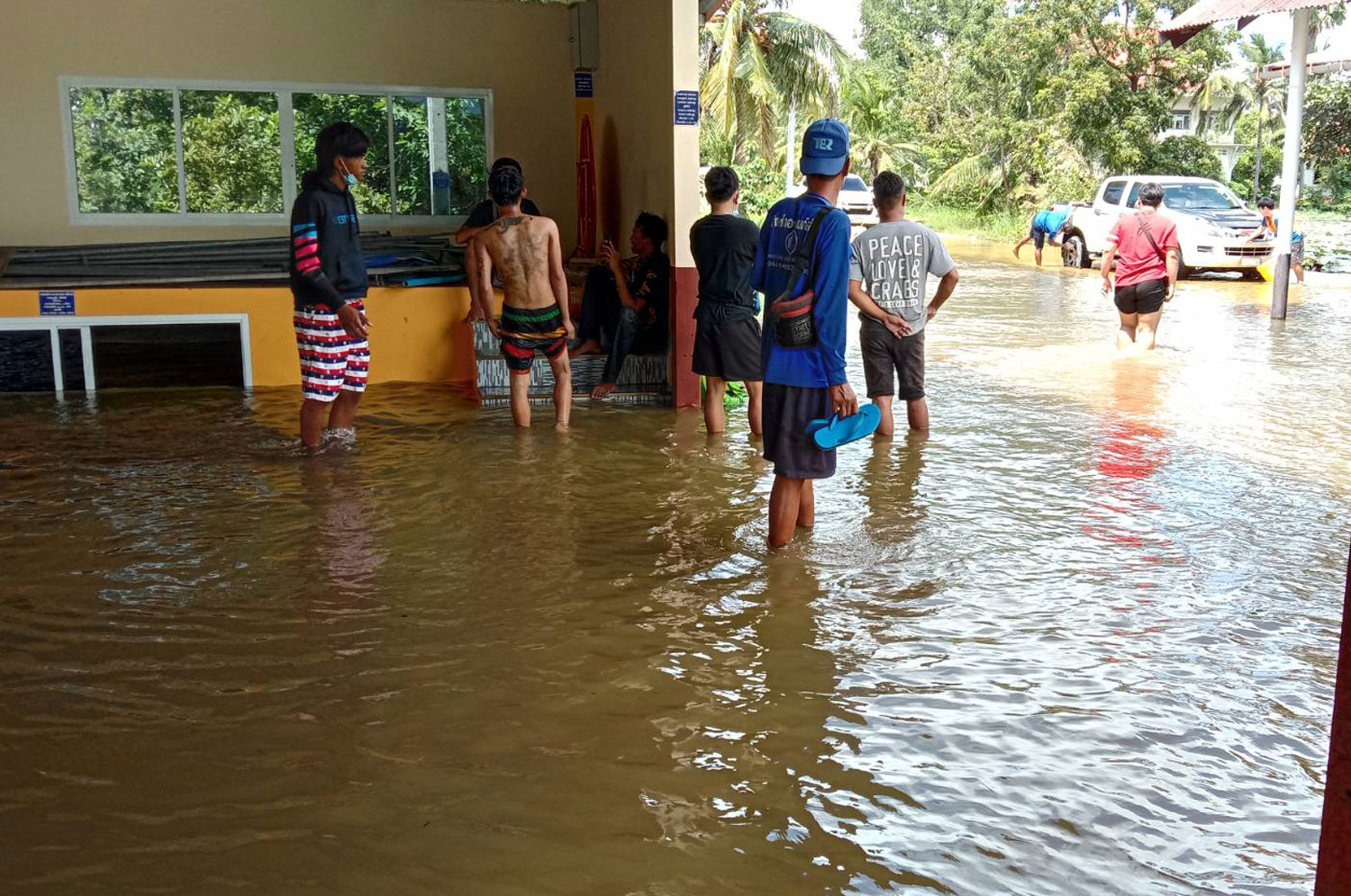 Local people help evacuate belongings at Wat Dan Ting in Non Sung district after the Lam Chiang Krai River burst its banks and flooded Dan Ting village on Thursday. (Photo: Prasit Tangprasert)