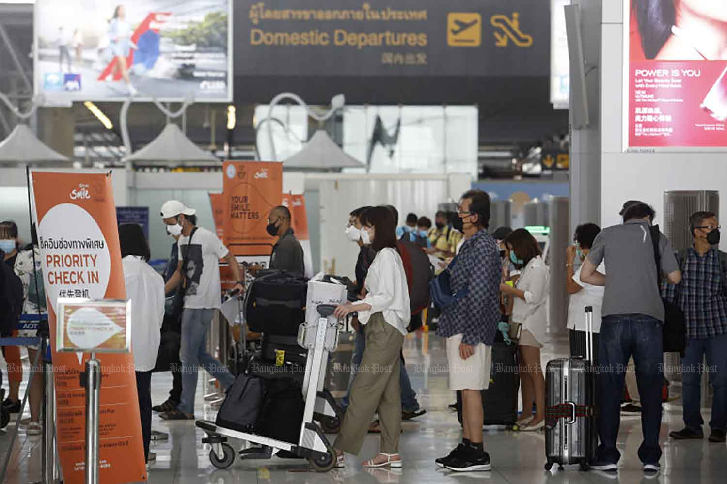 Domestic travellers are at Suvarnabhumi airport early this month when domestic flights resumed. The National Communicable Disease Committee decided on Thursday that some tourist areas should welcome foreign visitors in November and shorten their quarantine from 14 days. (Photo: Wichan Charoenkiatpakul)