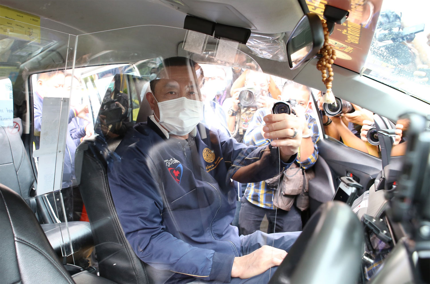 Transport Minister Saksayam Chidchob sits in a taxi fitted with an acrylic partition as he opens a ceremony to launch the pilot project targeting 3,000 taxis by October this year. (Photo: Department of Land Transport)