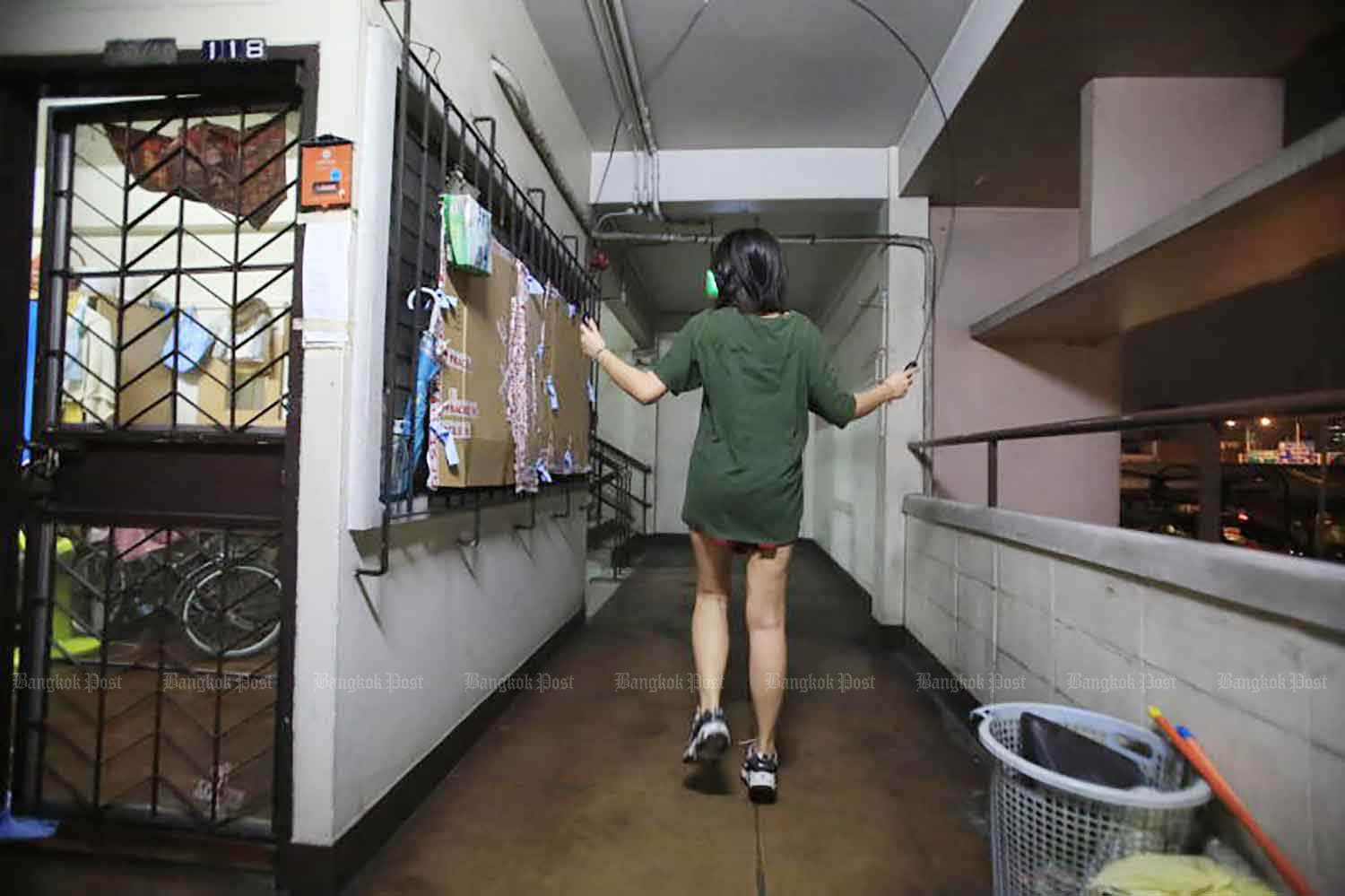 A woman at a Din Daeng flat exercises with a skipping rope on Friday night as anti-government protesters were gathering at Din Daeng junction for a rally against Prime Minister Prayut Chan-o-cha. (Photo: Pornprom Satrabhaya)