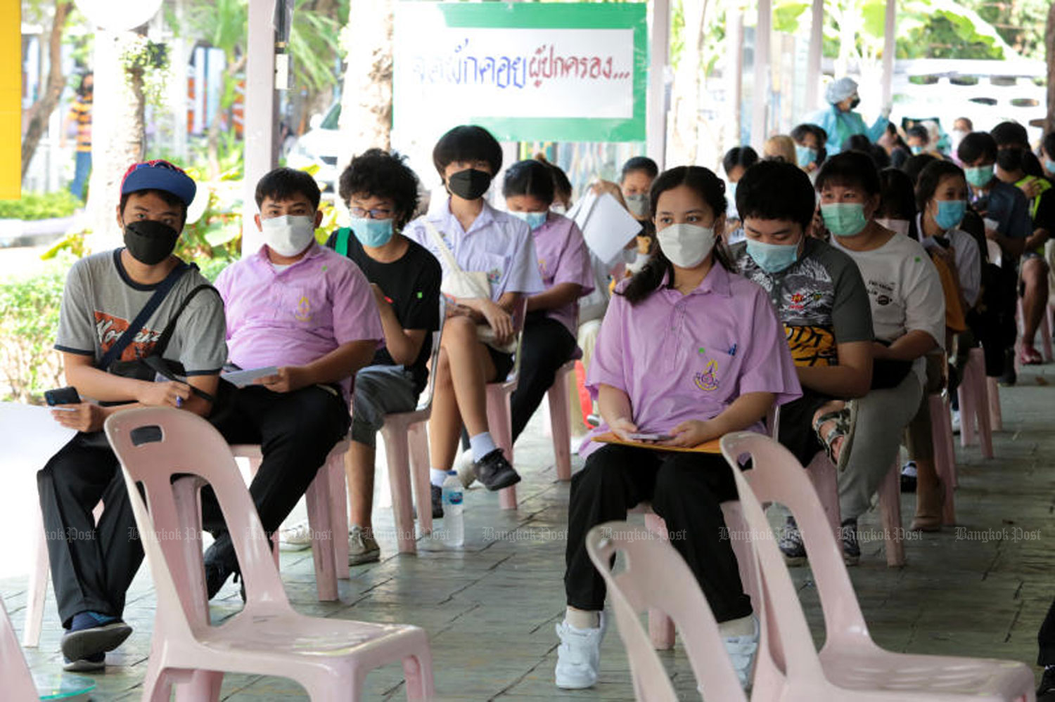 Students wait their turn to receive a Pfizer vaccine shot at Prachaniwes School in Bangkok's Chatuchak district on Oct 4. (Photo by Chanat Katanyu)