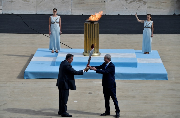 Yu Zaiqing (R) receives the torch with the Olympic flame from president of the Hellenic Olympic Committee Spyros Capralos Yu Zaiqing (R) receives the torch with the Olympic flame from president of the Hellenic Olympic Committee Spyros Capralos