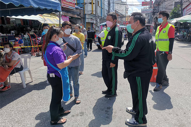 Officials talk to vendors on Wednesday outside Ton Lamyai Market, one of the three markets in Chiang Mai city which are closed until Saturday due to Covid-19 infections. (Photo from Chiang Mai public health office Facebook account)