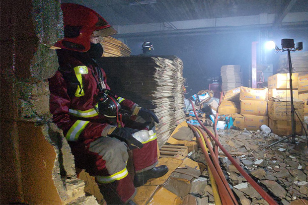 A firefighter surveys the fire damage to supplies and machinery at the Watana Footwear factory in Bang Phli district of Samut Prakan on Tuesday night. (Photo: Sutthiwit Chaiyutworakan) A firefighter surveys the fire damage to supplies and machinery at the Watana Footwear factory in Bang Phli district of Samut Prakan on Tuesday night. (Photo: Sutthiwit Chaiyutworakan)