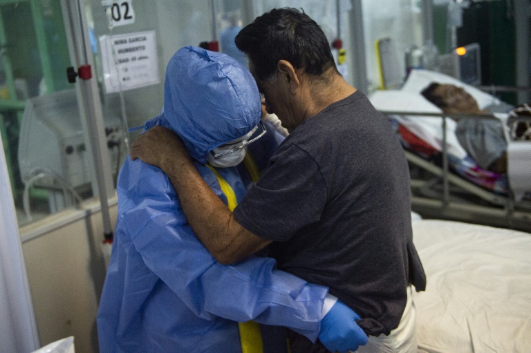 In this file photo taken on October 19, 2021, a health professional assists a COVID-19 patient at a hospital in northern Peru In this file photo taken on October 19, 2021, a health professional assists a COVID-19 patient at a hospital in northern Peru