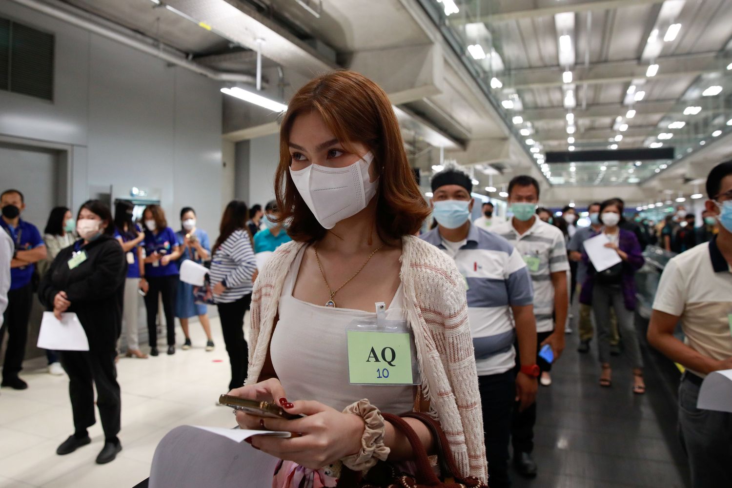 Volunteers line up during a drill as they prepare to reopen for tourists with coronavirus disease prevention measures at Suvarnabhumi airport on Wednesday. (Reuters photo)