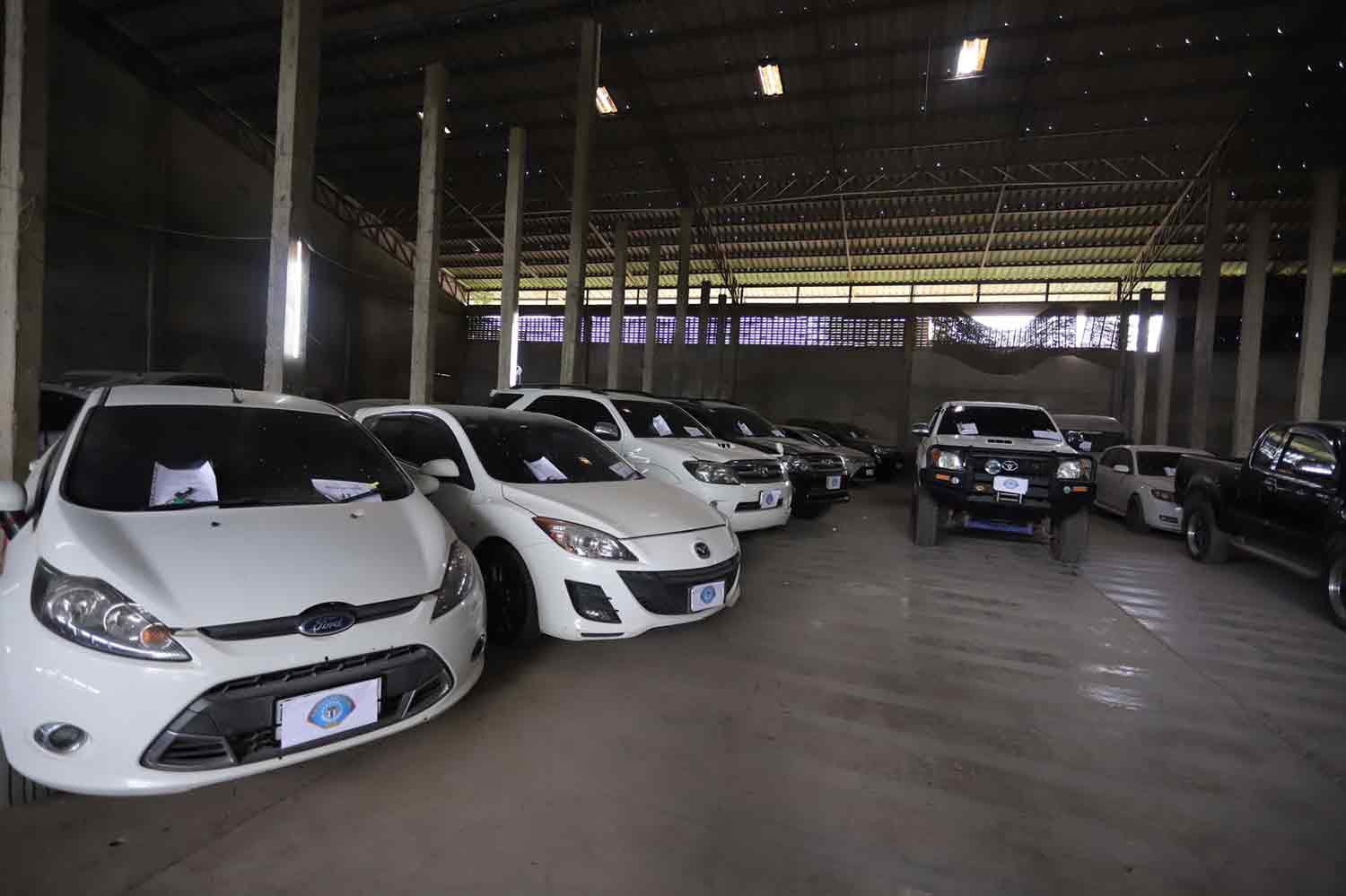 Police impound the vehicles at the unregistered warehouse in Muang district, Phitsanulok, as they arrested loan shark suspects there on Friday morning. (Photo supplied)