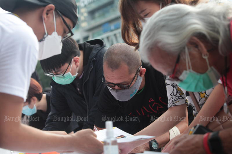 People put their signatures on a petition to end the lese majeste law on Sunday. (Photo: Apichart Jinakul)