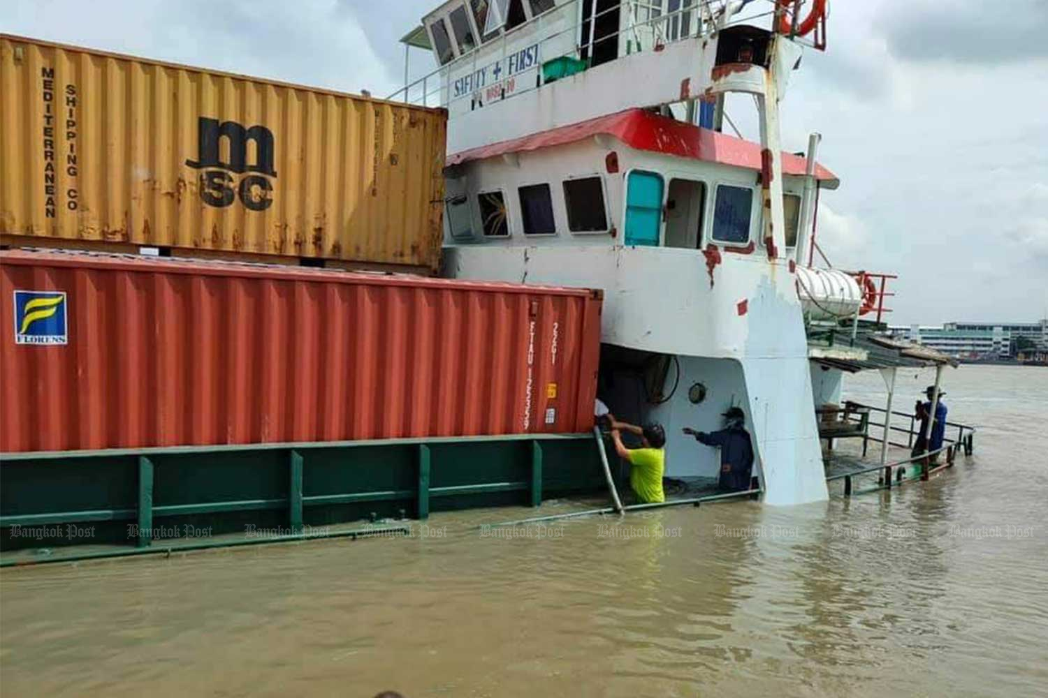 The stricken cargo vessel O.P.K 3, grounded on the shoreline of the Chao Phraya River in Samut Prakan province after being hit by the NP Pathum Thani on Tuesday morning.  (Photo:@Ruamduay twitter account)