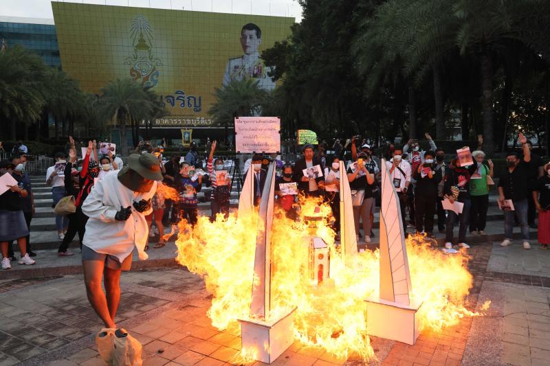 Protesters set fire at model of the Democracy Monument outside the Constitutional Court premises in protest against the ruling against the three activists on Wednesday. (AFP photo)