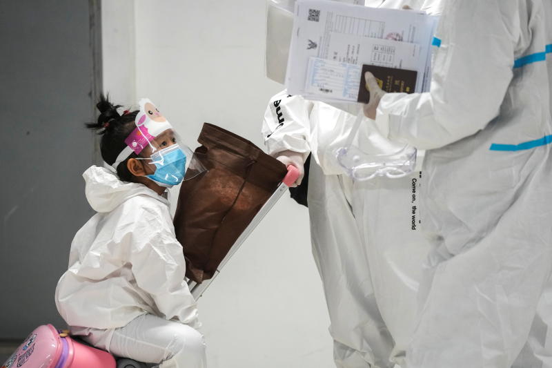 A chinese tourist wearing a protective suit is seen as she arrives with her parent at Suvarnabhumi airport during the first day of the country's reopening campaign on Nov 1, 2021. (Reuters photo)