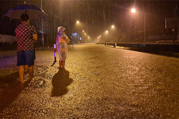 Residents at Bang Klong Luek in Hat Yai district of Songkhla watch as continuous rain floods a main road in Muang district in the early hours of Friday. (Photo: Assawin Pakkawan)