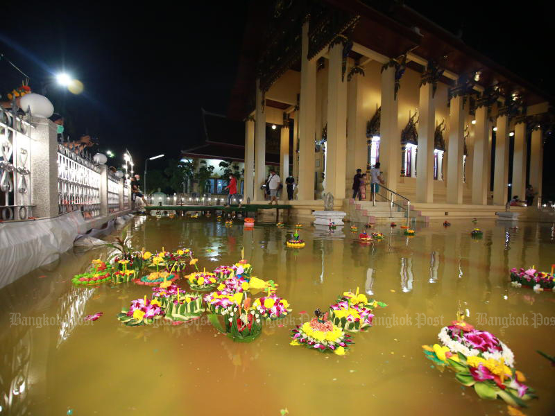 Krathong are floated in the flooded area around the main ordination hall of Wat Arsasongkhram in Phra Pradaeng district of Samut Prakan on Friday evening. (Photo: Somchai Poomlard)