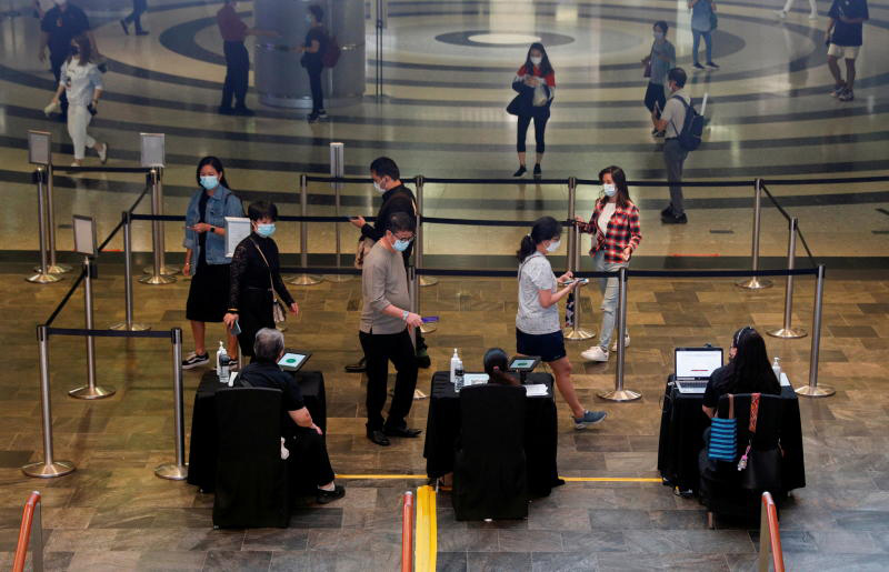 People verify their vaccination statuses as they enter a mall in Singapore on Nov 18, 2021. (Reuters photo) People verify their vaccination statuses as they enter a mall in Singapore on Nov 18, 2021. (Reuters photo)
