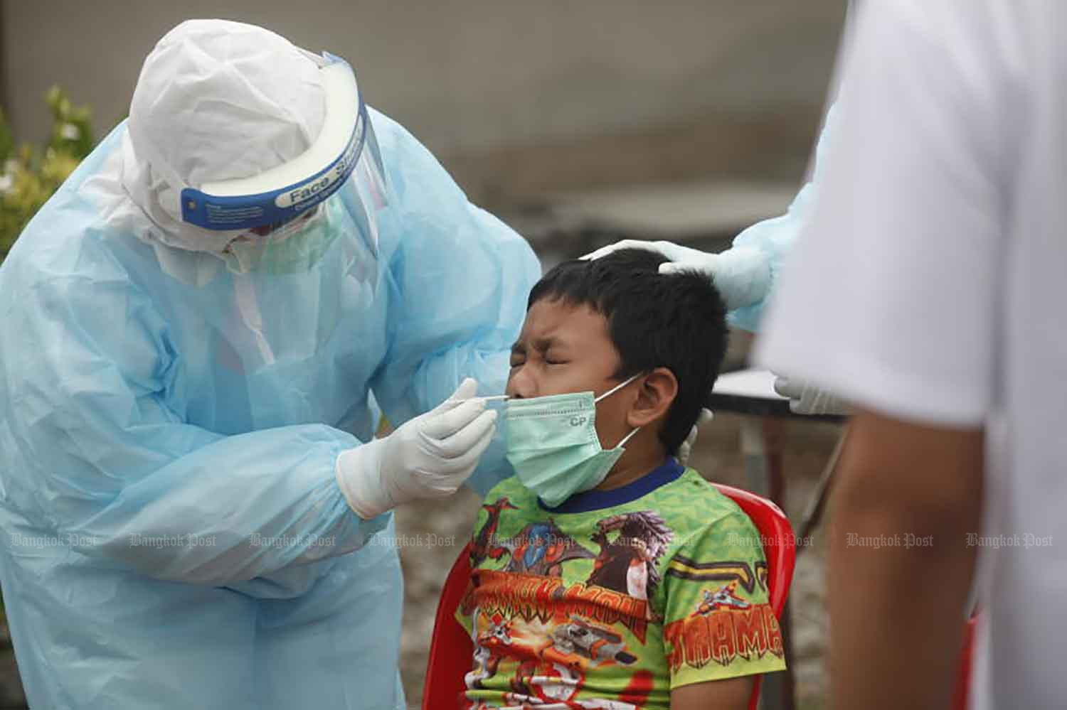 A medical worker takes a nasal swab for Covid-19 testing from a boy in Sai Mai district, Bangkok. (Photo: Nutthawat Wicheanbut) A medical worker takes a nasal swab for Covid-19 testing from a boy in Sai Mai district, Bangkok. (Photo: Nutthawat Wicheanbut)