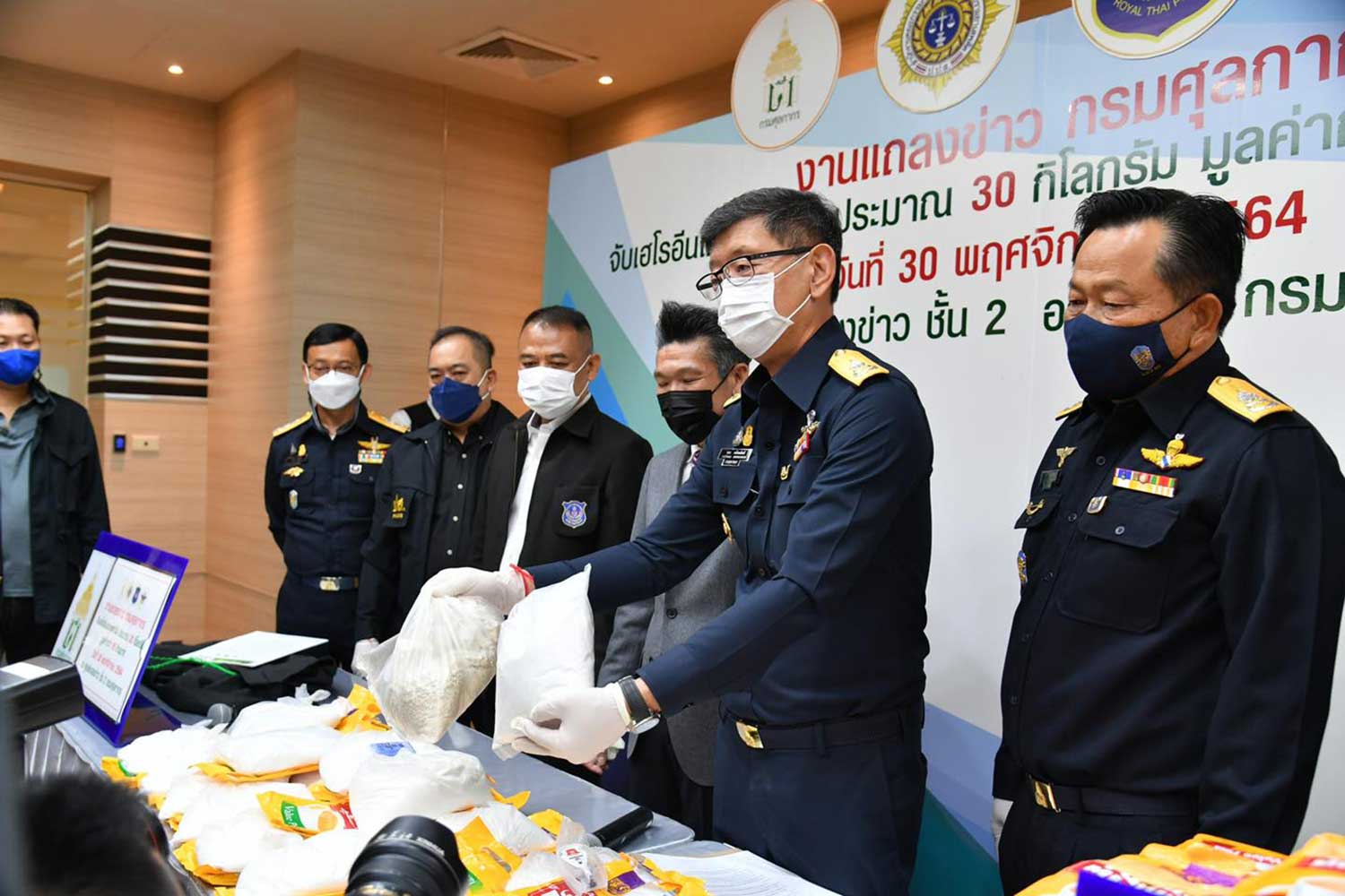 Customs Department director-general Patchara Anuntasilpa shows the heroin and ketamine found in the bags of two Pakistani men who arrived at Suvarnabhumi airport from Dubai, during a media briefing on Tuesday. (Photo: Customs Department Facebook page) Customs Department director-general Patchara Anuntasilpa shows the heroin and ketamine found in the bags of two Pakistani men who arrived at Suvarnabhumi airport from Dubai, during a media briefing on Tuesday. (Photo: Customs Department Facebook page)