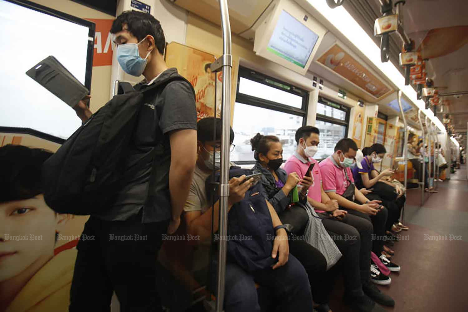 Commuters on an electric train wear face masks to protect themselves from Covid-19 in Bangkok in July. (Photo: Nutthawat Wicheanbut)