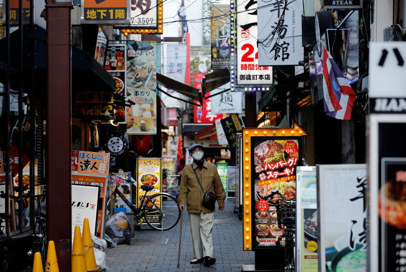 A man wearing a protective mask amid the coronavirus disease outbreak walks in a restaurant district in Tokyo, Japan, on Wednesday. (Reuters photo) A man wearing a protective mask amid the coronavirus disease outbreak walks in a restaurant district in Tokyo, Japan, on Wednesday. (Reuters photo)