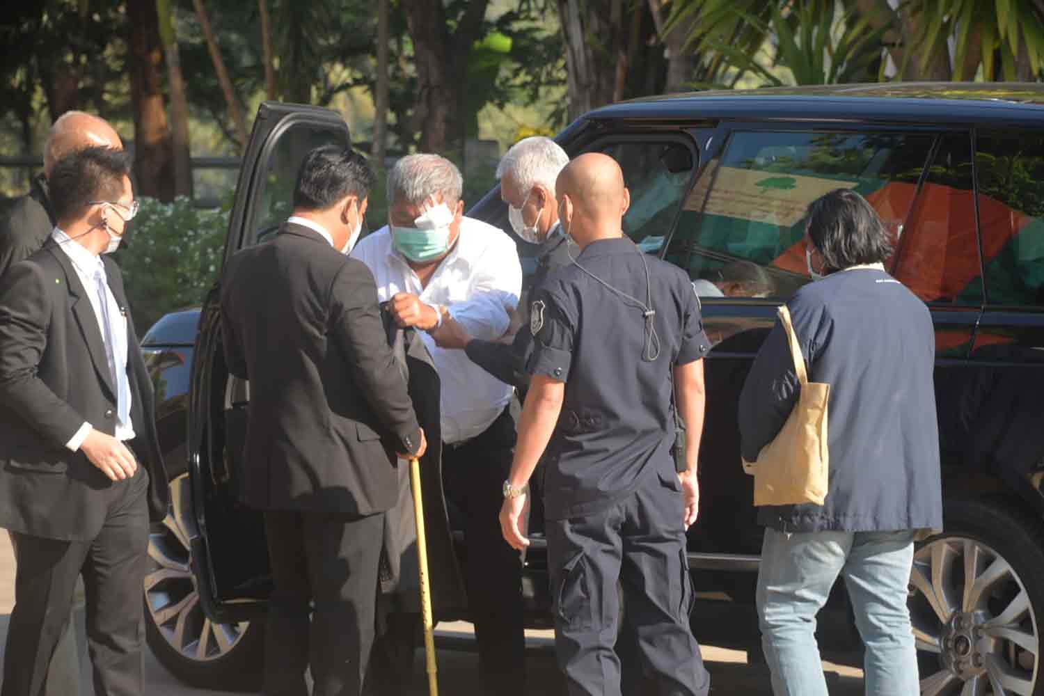 Construction tycoon Premchai Karnasuta, in a white shirt, arrives at the Thong Pha Phum district court in Kanchanaburi province on Wednesday morning to hear the Supreme Court's ruling on charges of illegal hunting in a wildlife sanctuary nearly four years ago. (Photo: Piyarat Chongcharoen)