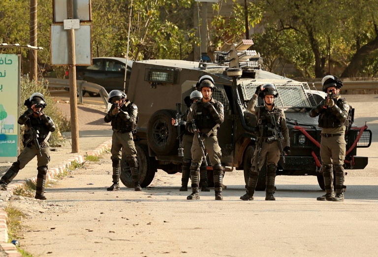 Israeli border guards block the entrance to the Palestinian village of al-Lubban al-Sharqiya, near Nablus city in the occupied West Bank, during a demonstration by settlers on December 14, 2021. Israeli border guards block the entrance to the Palestinian village of al-Lubban al-Sharqiya, near Nablus city in the occupied West Bank, during a demonstration by settlers on December 14, 2021.