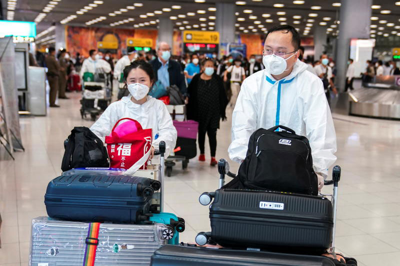 Chinese tourists wearing protective suits arrive at Suvarnabhumi airport during the first day of the country's reopening campaign on Nov 1, 2021. The country continues to suspend the quarantine-free scheme for fully vaccinated air travellers. (Reuters photo)