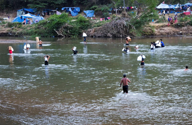 Myanmar refugees, who have fled a flare-up in fighting between the Myanmar army and insurgent groups and settled temporarily on the Moei River bank, receive aid from Thailand on the Thai-Myanmar border, in Mae Sot district of Tak on Tuesday. (Reuters photo) Myanmar refugees, who have fled a flare-up in fighting between the Myanmar army and insurgent groups and settled temporarily on the Moei River bank, receive aid from Thailand on the Thai-Myanmar border, in Mae Sot district of Tak on Tuesday. (Reuters photo)