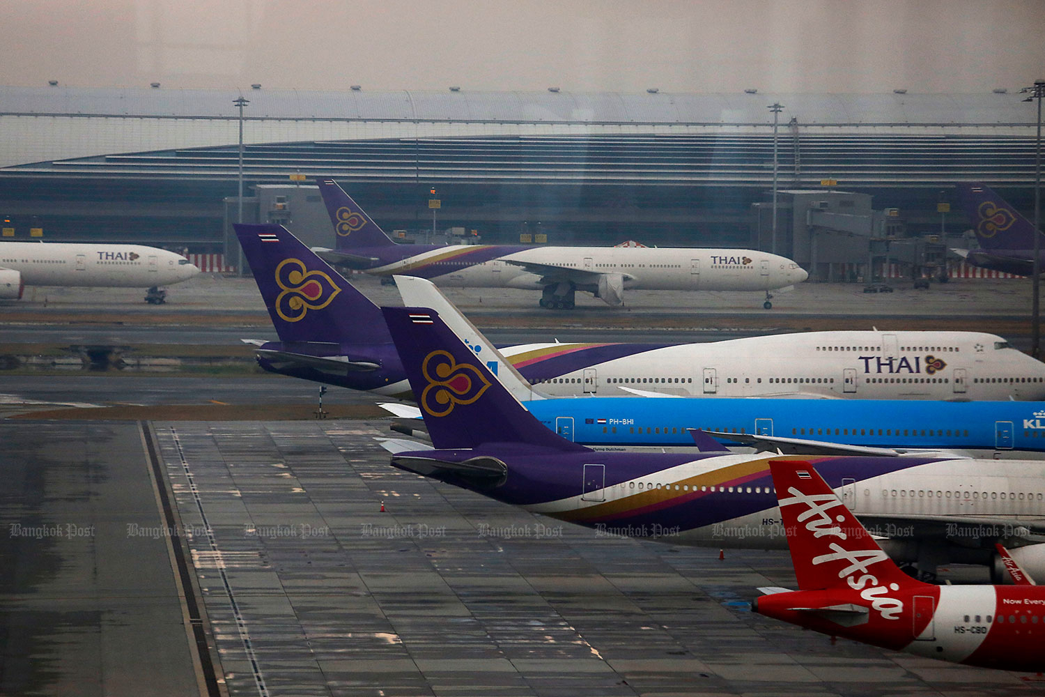 Aircraft of Thai AirAsia and Thai Airways International are parked at Suvarnabhumi airport. (Photo by Wichan Charoenkiatpakul)